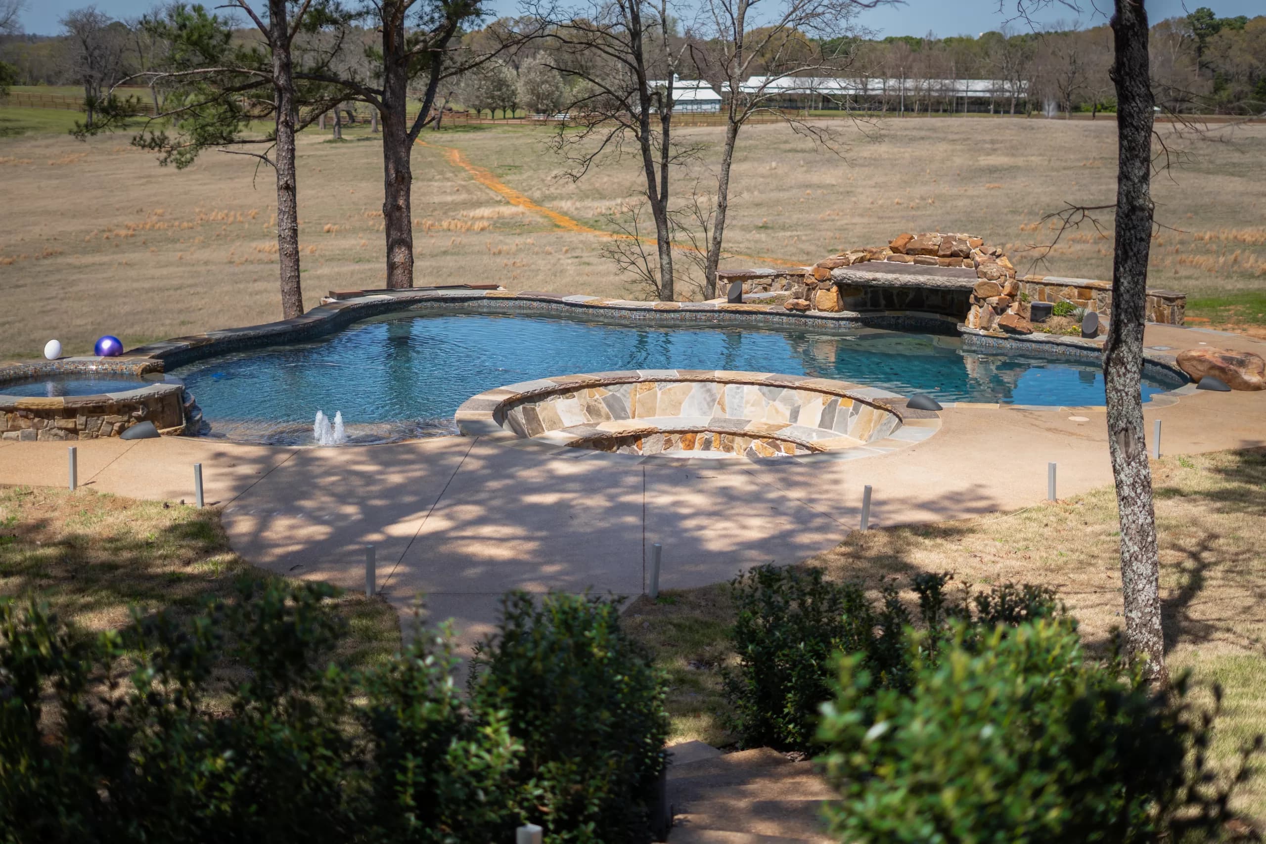Finished freeform gunite pool with a rock waterfall and a raised spa, Gunite Pool Construction: Finished